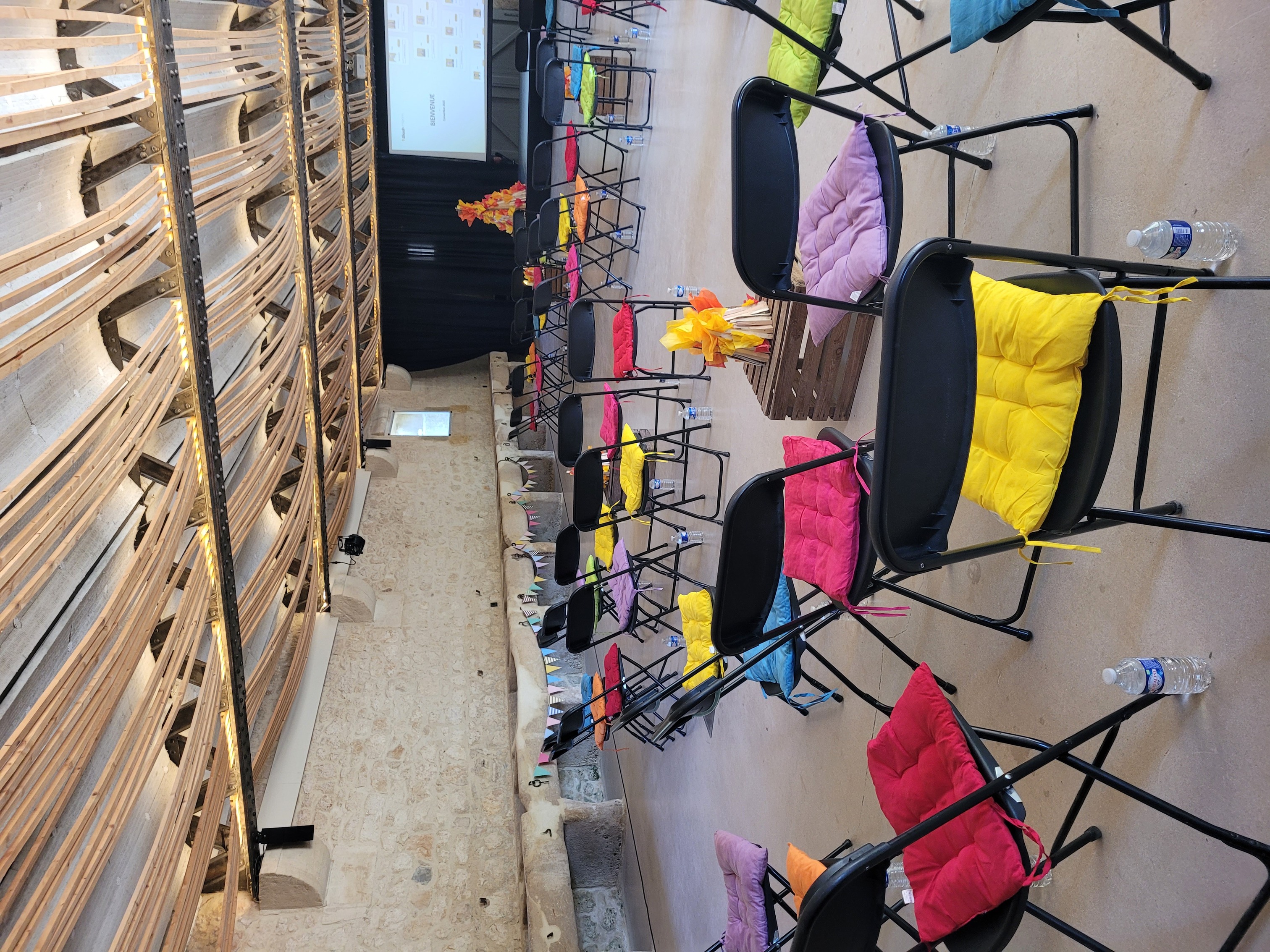 Plénière d'une convention sur le thème colonie de vacances avec des assises colorées et un feu de camp géant fait main